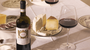 a bottle of Lamole di Lamole Chianti Classico on a table with cheese and a glass of red wine