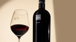 bottle of Cantina Mesa Buio next to a glass of red wine